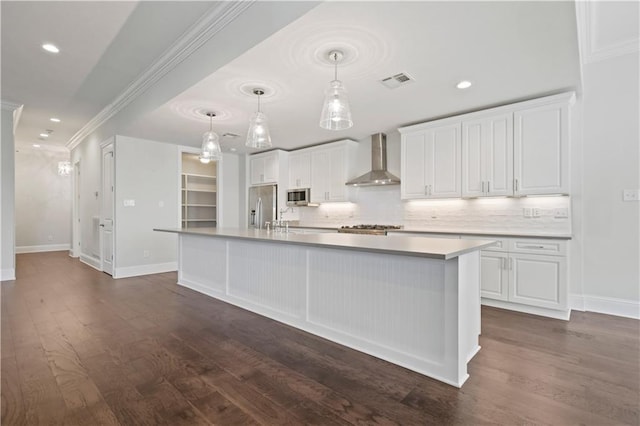 kitchen featuring white cabinets, a center island with sink, wall chimney exhaust hood, and appliances with stainless steel finishes