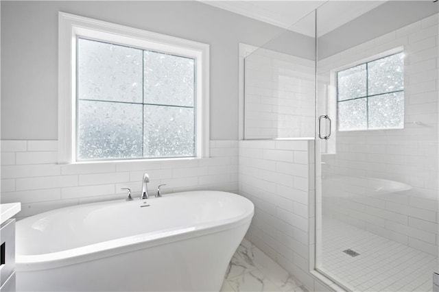 bathroom with plus walk in shower, vanity, a wealth of natural light, and tile walls