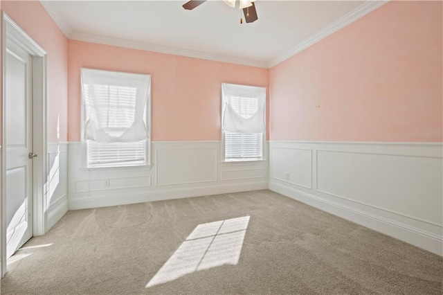 carpeted spare room featuring ceiling fan, plenty of natural light, and ornamental molding