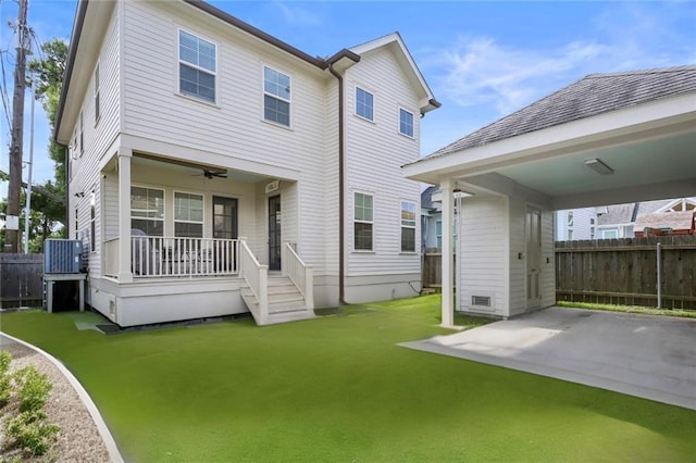 back of house with a lawn, covered porch, and central AC