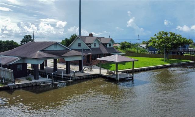 view of dock with a water view and a lawn