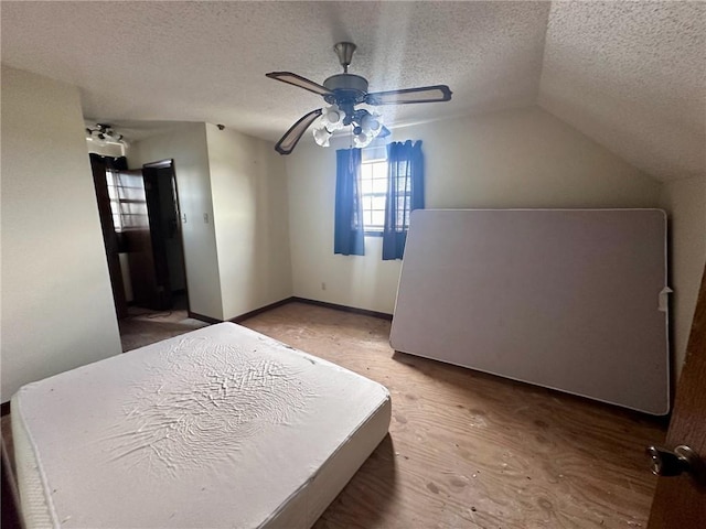 bedroom with ceiling fan, wood-type flooring, lofted ceiling, and a textured ceiling