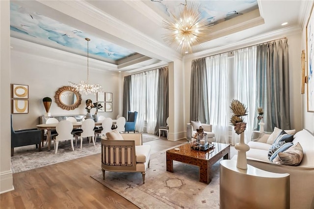 sitting room with a raised ceiling, plenty of natural light, and a chandelier