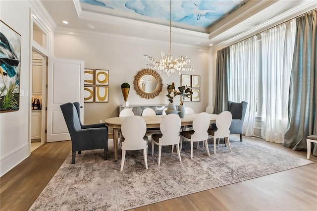 dining room with a tray ceiling, a wealth of natural light, dark hardwood / wood-style floors, and an inviting chandelier