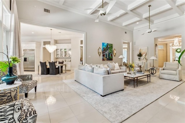 tiled living room featuring beamed ceiling, a high ceiling, ceiling fan with notable chandelier, and coffered ceiling