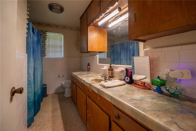 bathroom featuring plenty of natural light, vanity, tile walls, and toilet