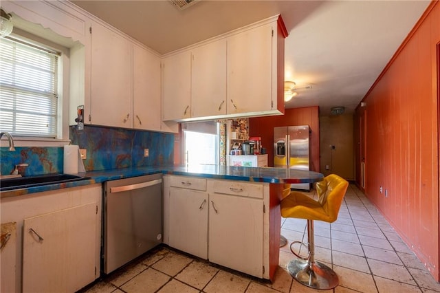 kitchen featuring white cabinets, appliances with stainless steel finishes, kitchen peninsula, and sink