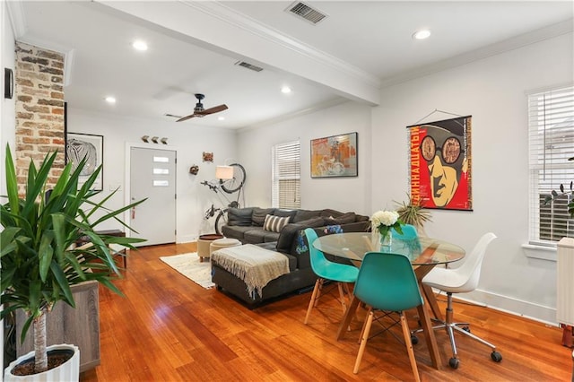 living room featuring hardwood / wood-style floors, ceiling fan, and crown molding