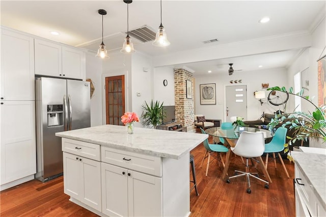 kitchen with stainless steel fridge with ice dispenser, dark hardwood / wood-style floors, white cabinetry, and a kitchen island