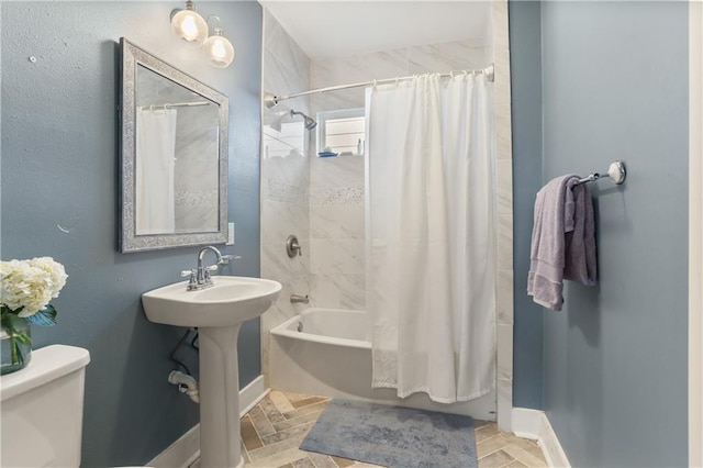 full bathroom with toilet, shower / bathtub combination with curtain, and sink