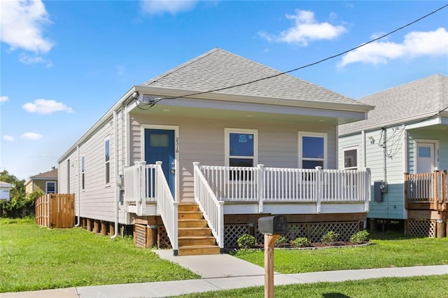 view of front of house featuring covered porch and a front lawn