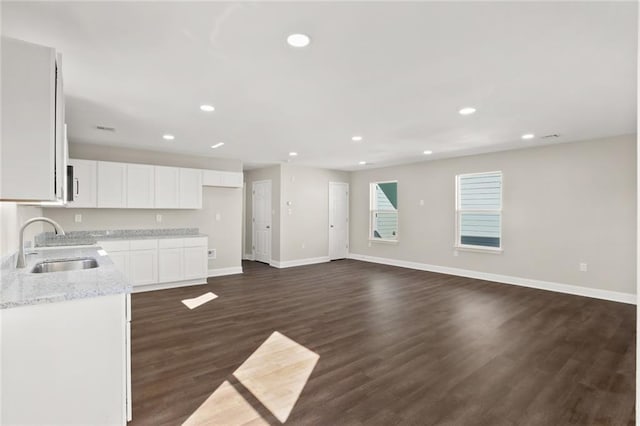 kitchen featuring white cabinetry, sink, light stone countertops, and dark hardwood / wood-style floors