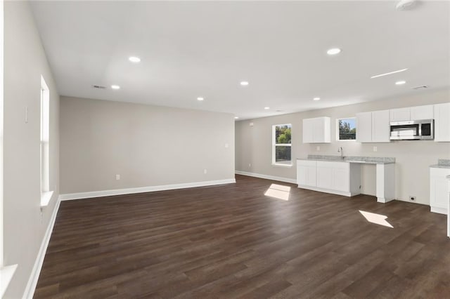 unfurnished living room with dark wood-type flooring and sink