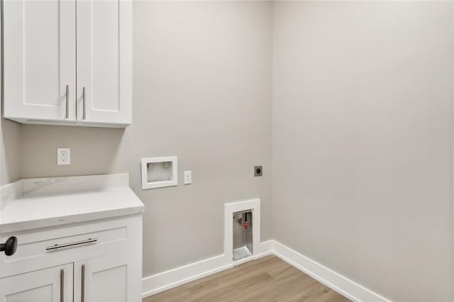 laundry room featuring hookup for an electric dryer, washer hookup, light wood-type flooring, and cabinets