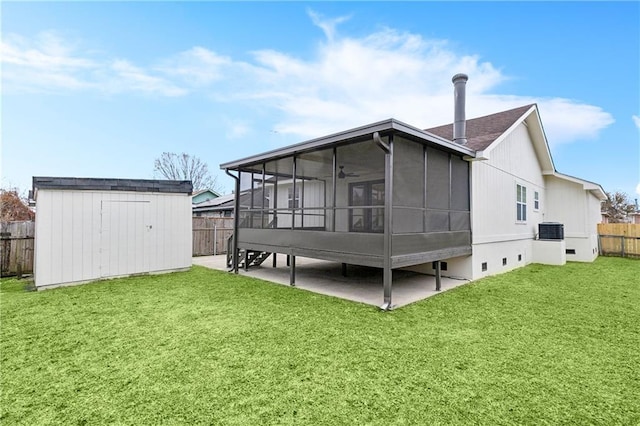 rear view of property with a patio, cooling unit, a yard, a sunroom, and a storage shed