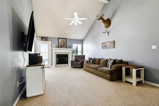 carpeted living room featuring a tile fireplace, high vaulted ceiling, and ceiling fan