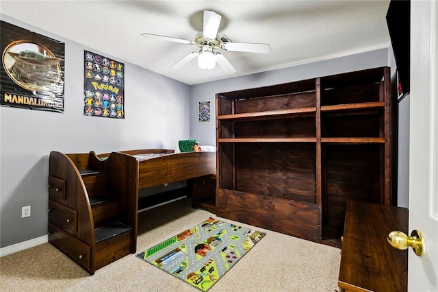 carpeted office space featuring ceiling fan