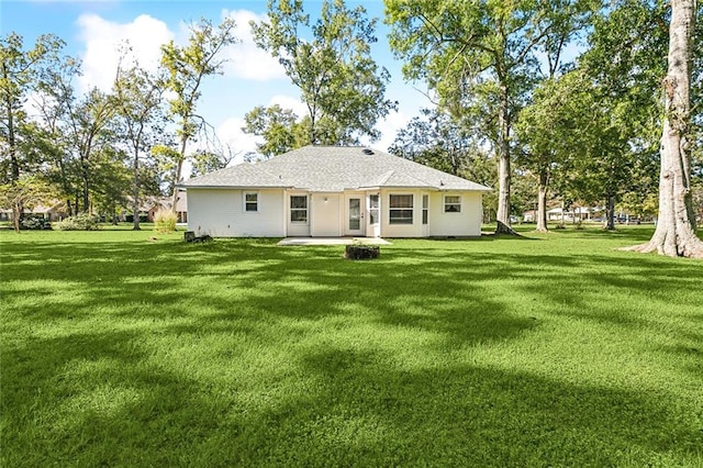 rear view of property featuring a patio area and a lawn