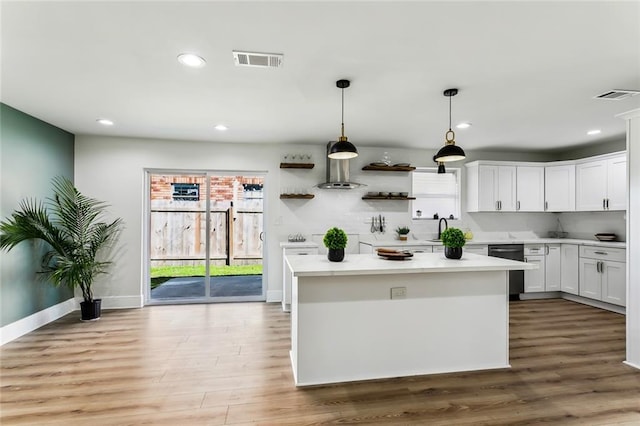 kitchen with light hardwood / wood-style flooring, white cabinets, hanging light fixtures, and a kitchen island