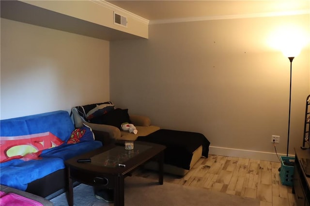 sitting room with crown molding and light hardwood / wood-style flooring