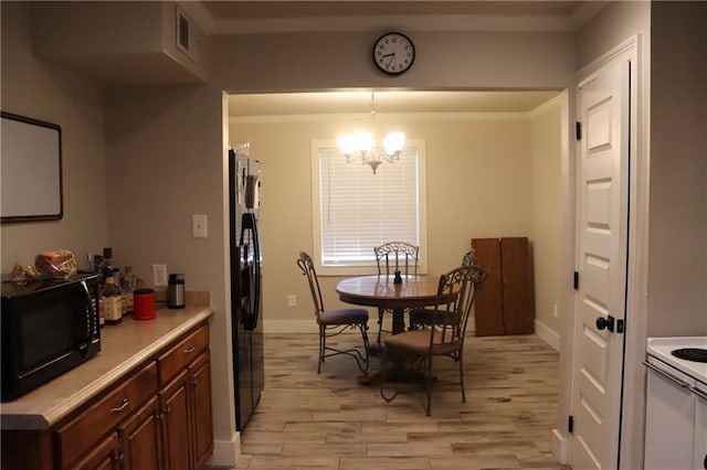 dining space featuring a chandelier, light hardwood / wood-style flooring, and ornamental molding