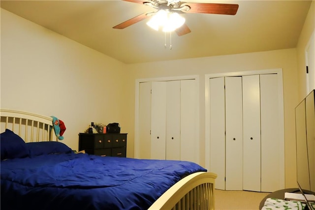 bedroom with multiple closets, ceiling fan, and carpet floors