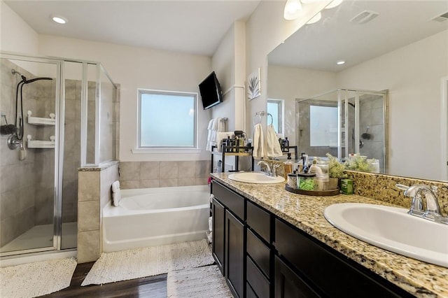 bathroom featuring vanity, plus walk in shower, and wood-type flooring