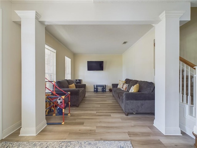 1024 Claire Dr, Slidell, LA 70461 - living room featuring decorative columns, stairs, light wood finished floors, and ornamental molding