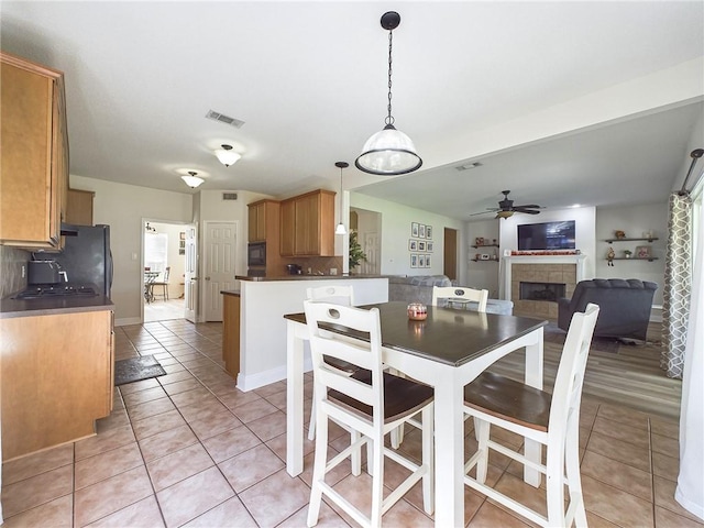 1024 Claire Dr, Slidell, LA 70461 - dining room featuring light tile patterned floors, a fireplace, and ceiling fan