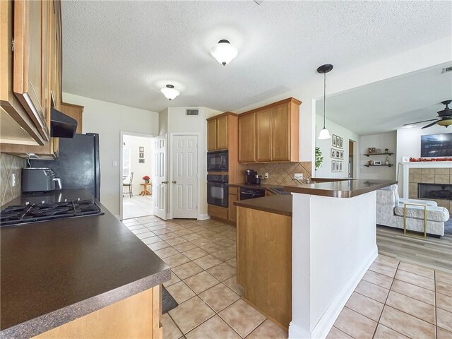 1024 Claire Dr, Slidell, LA 70461 - kitchen featuring black appliances, dark countertops, open floor plan, a peninsula, and ceiling fan