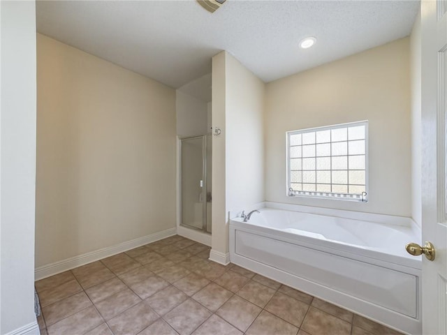 1024 Claire Dr, Slidell, LA 70461 - full bathroom featuring a bath, a stall shower, tile patterned flooring, and a textured ceiling