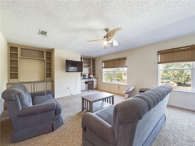 carpeted living room with ceiling fan and a textured ceiling