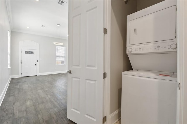 washroom featuring stacked washer / dryer, hardwood / wood-style floors, and ornamental molding