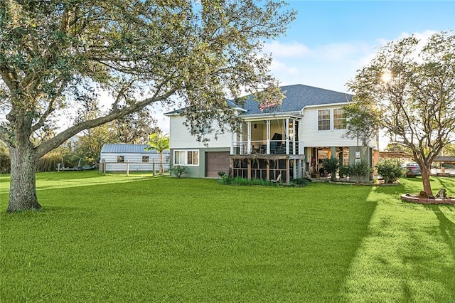 rear view of house featuring a lawn and a sunroom