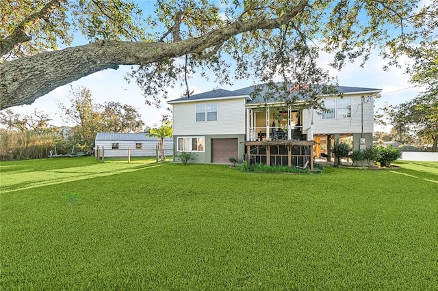 back of house featuring a garage and a lawn