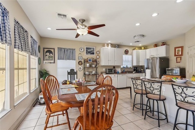 dining space with ceiling fan and light tile patterned flooring