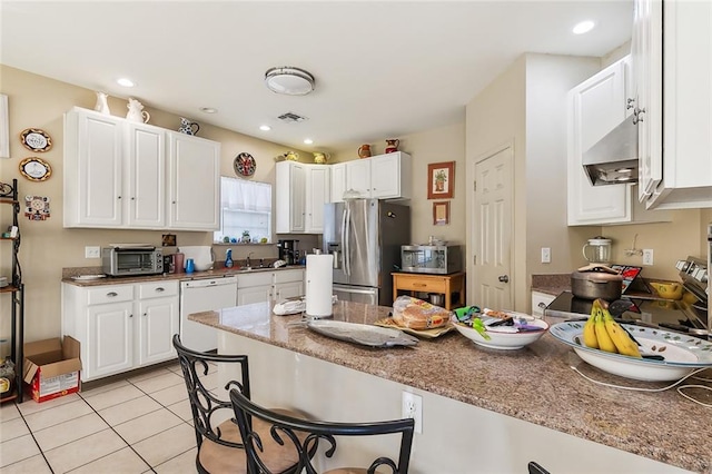 kitchen with stone counters, white cabinets, sink, light tile patterned flooring, and stainless steel appliances