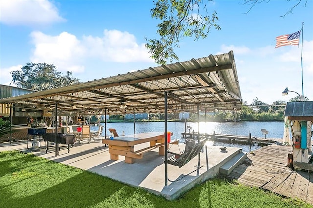 view of dock with a yard and a water view