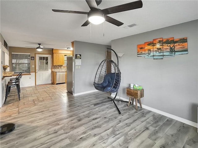 sitting room with ceiling fan and light wood-type flooring