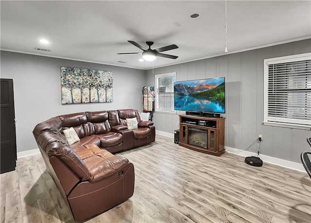 living room with ceiling fan, crown molding, and light hardwood / wood-style flooring