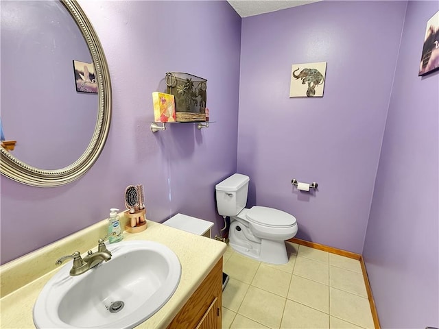 bathroom with tile patterned flooring, vanity, and toilet