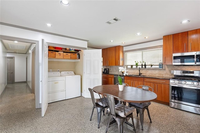 kitchen featuring separate washer and dryer, decorative backsplash, stainless steel appliances, and sink