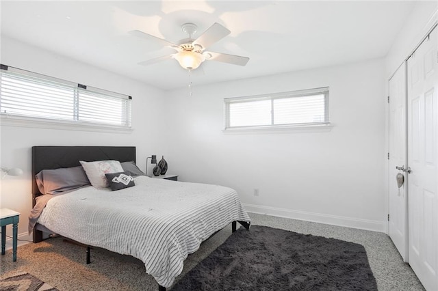 carpeted bedroom with a closet, multiple windows, and ceiling fan