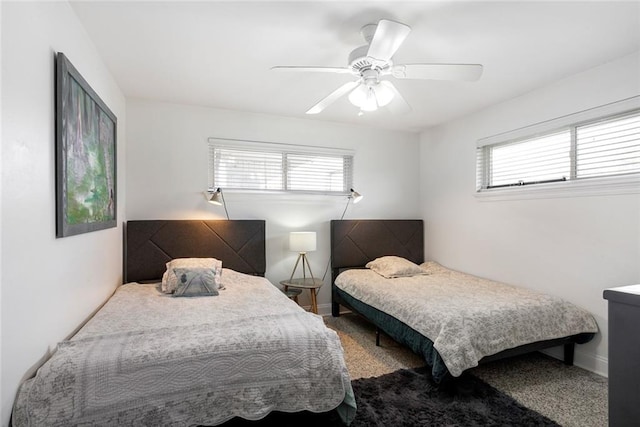 carpeted bedroom featuring multiple windows and ceiling fan