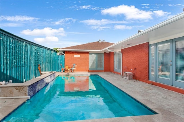 view of swimming pool with french doors and a patio