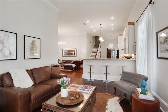 living room featuring ornamental molding, dark hardwood / wood-style flooring, and a notable chandelier