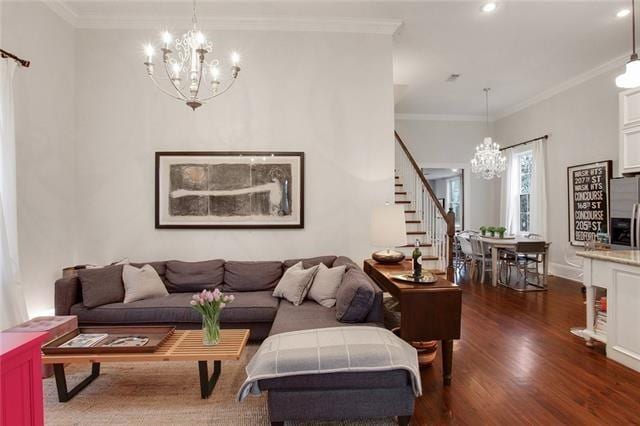 living room featuring a notable chandelier, ornamental molding, and dark wood-type flooring