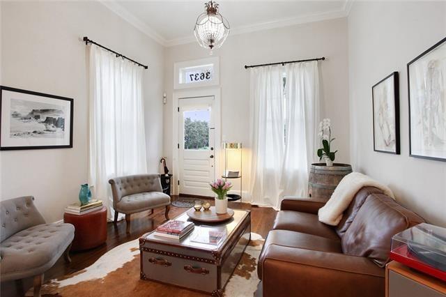 living area featuring hardwood / wood-style flooring, crown molding, and an inviting chandelier