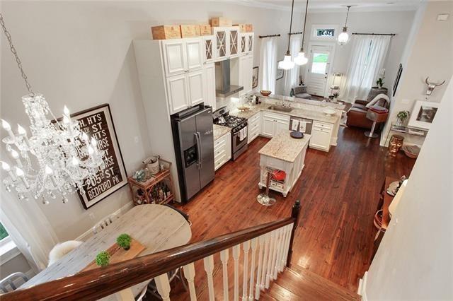 kitchen with a center island, dark hardwood / wood-style floors, extractor fan, decorative light fixtures, and appliances with stainless steel finishes