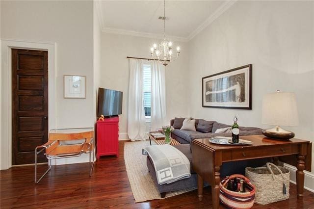 living room featuring crown molding, dark hardwood / wood-style flooring, and a chandelier